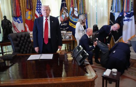 WASHINGTON, DC - NOVEMBER 06: U.S. President Donald Trump stands by as attendees help Novo Nordisk executive Gordon Findlay after he collapsed during during an event on lowering drug prices in the Oval Office at the White House on November 06, 2025 in Washington, DC. Trump announced that his administration has reached agreements with drugmakers Eli Lilly and Novo Nordisk that would lower the price of some GLP-1 weight loss medications. (Photo by Andrew Harnik/Getty Images)