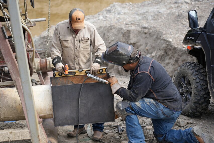 Freddy Dodge standing and Juan Ibarra kneeling, attching new sluice box