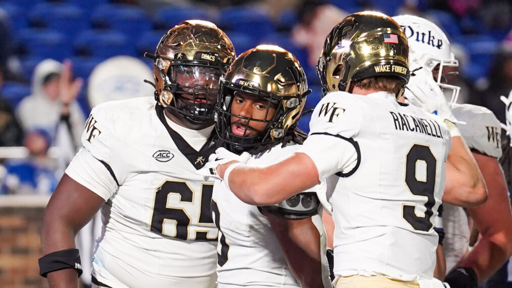Running back Ty Clark #0 of the Wake Forest Demon Deacons celebrates a touchdown with wide receiver Sawyer Racanelli #9 and Offensive lineman Clinton Richard #65 during the second half of the game at Wallace Wade Stadium on November 29, 2025 in Durham, North Carolina.