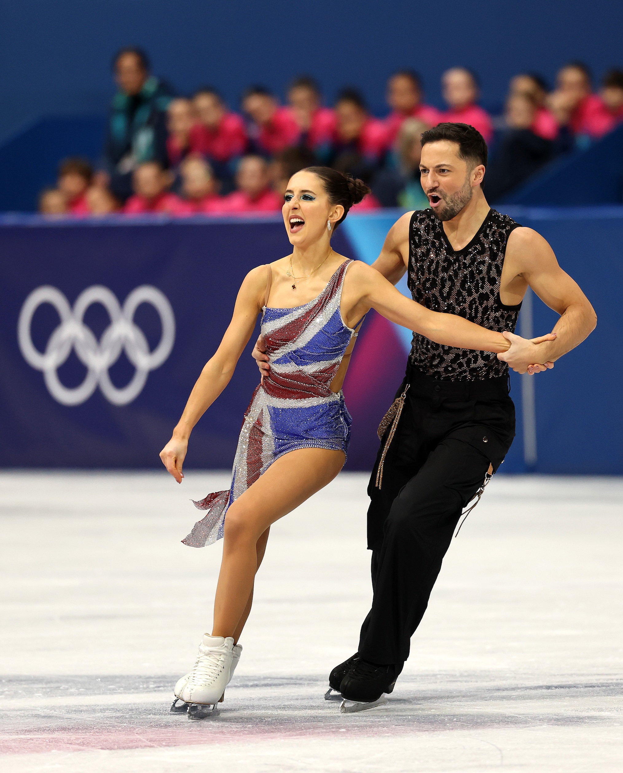Lilah Fear and partner Lewis Gibson of Team Great Britain compete in the Ice Dance - Rhythm Dance on day zero of the Milano Cortina 2026 Winter Olympic games at Milano Ice Skating Arena on February 06, 2026 in Milan, Italy.