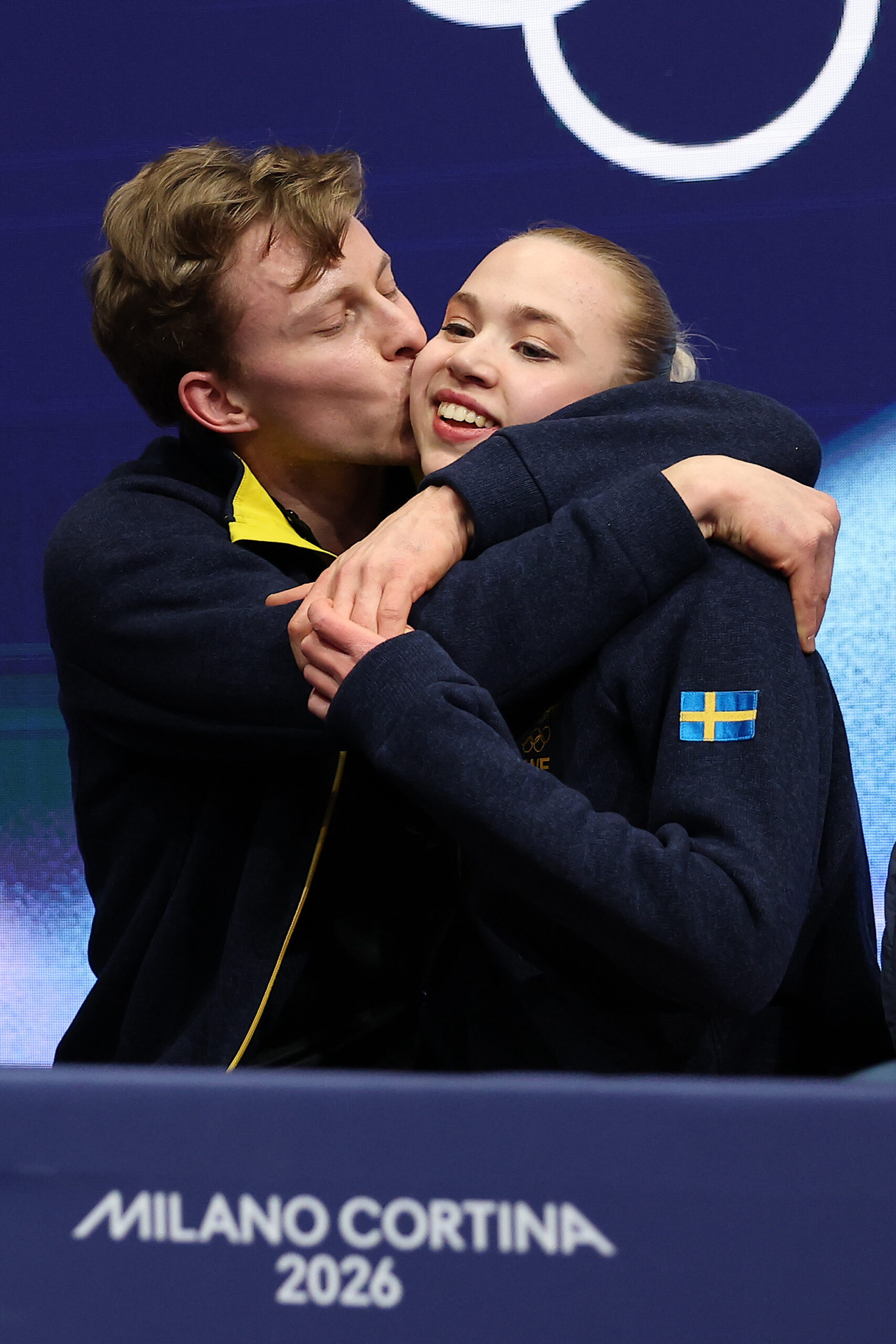 Milla Ruud Reitan and partner Nikolaj Majorov of Team Sweden react with their team in the Kiss and Cry zone after competing in Ice Dance - Rhythm Dance Qualification on day three of the Milano Cortina 2026 Winter Olympic games at Milano Ice Skating Arena on February 09, 2026 in Milan, Italy.