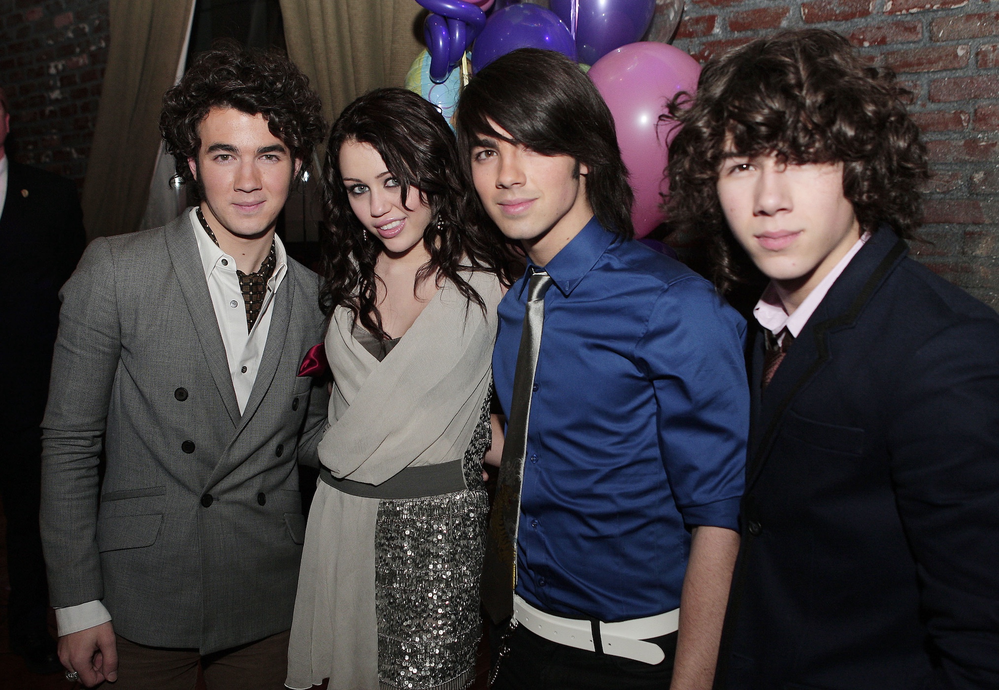 The Jonas Brothers, Kevin (L), Joe and Nick (R), pose with actress/singer Miley Cyrus at the afterparty for the premiere of Walt Disney Pictures' 