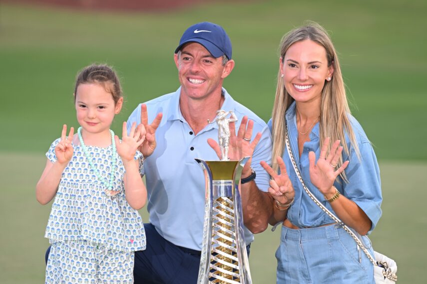Rory McIlroy of Northern Ireland poses with his Daughter, Poppy and Wife, Erica, holding 7 fingers to the camera, alongside the Race to Dubai trophy on the 18th green on day four of the DP World Tour Championship 2025 at Jumeirah Golf Estates on November 16, 2025 in Dubai, United Arab Emirates.