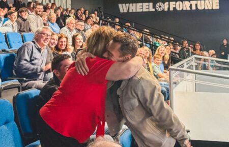 Ryan Seacrest hugging a 