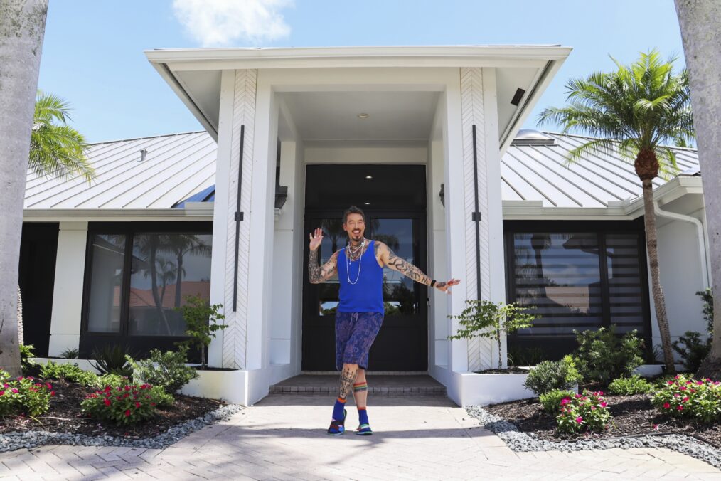 Host David Bromstad poses for a picture outside of House 2, Hero, Lago Creek, as seen on 'My Lottery Dream Home,' Season 18, HGTV.