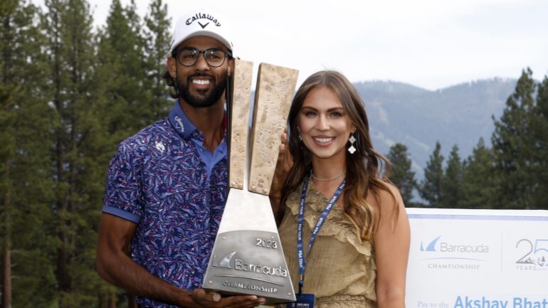 Akshay Bhatia of the United States poses with the trophy and his partner Presleigh Schultz after putting in to win on the 18th green during a playoff during the final round of the Barracuda Championship at Tahoe Mountain Club on July 23, 2023 in United States.