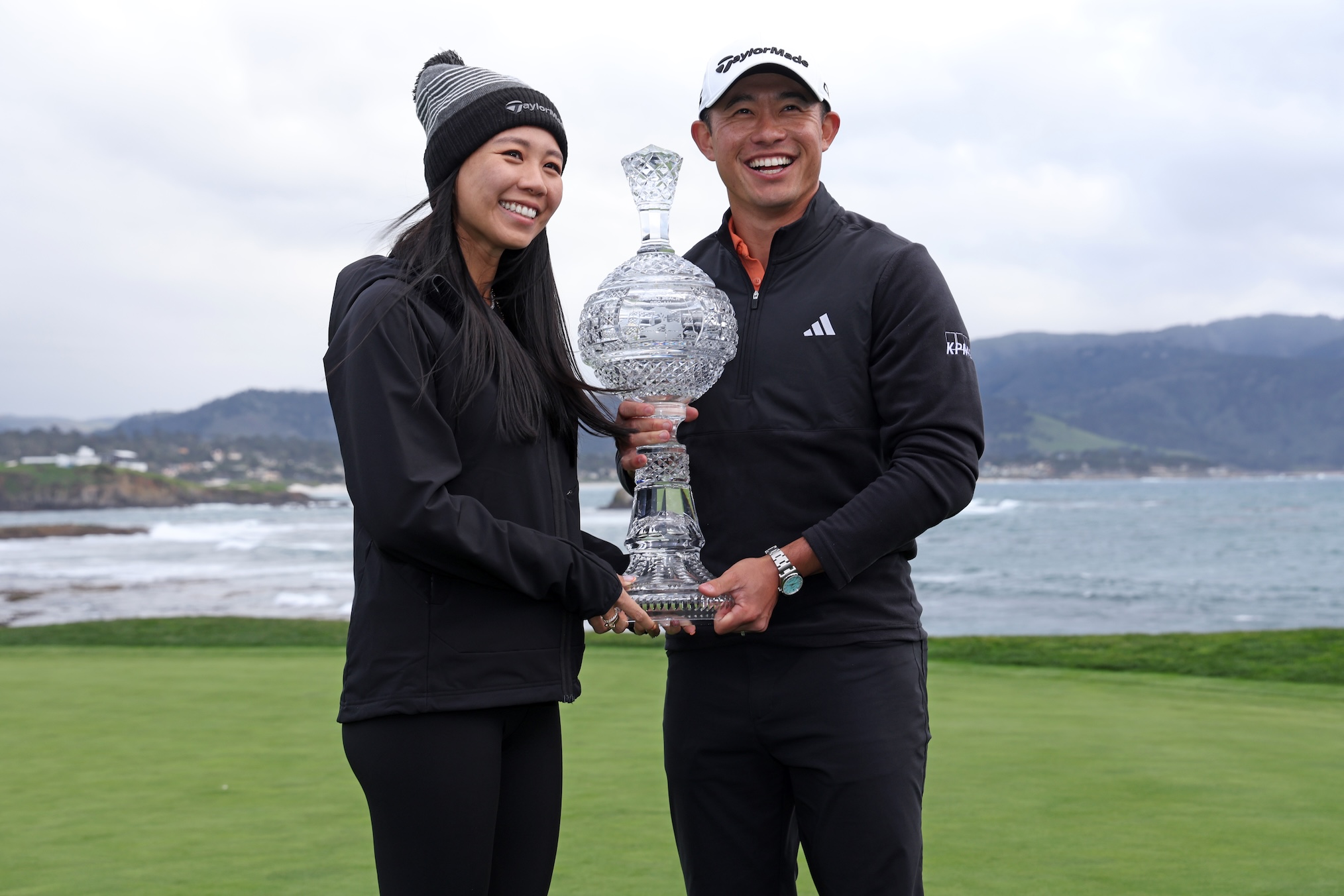 Collin Morikawa of the United States poses with his wife Katherine Zhu and the trophy after putting in to win on the 18th hole during the final round of the AT&T Pebble Beach Pro-Am 2026 at Pebble Beach Golf Links on February 15, 2026 in Pebble Beach, California.