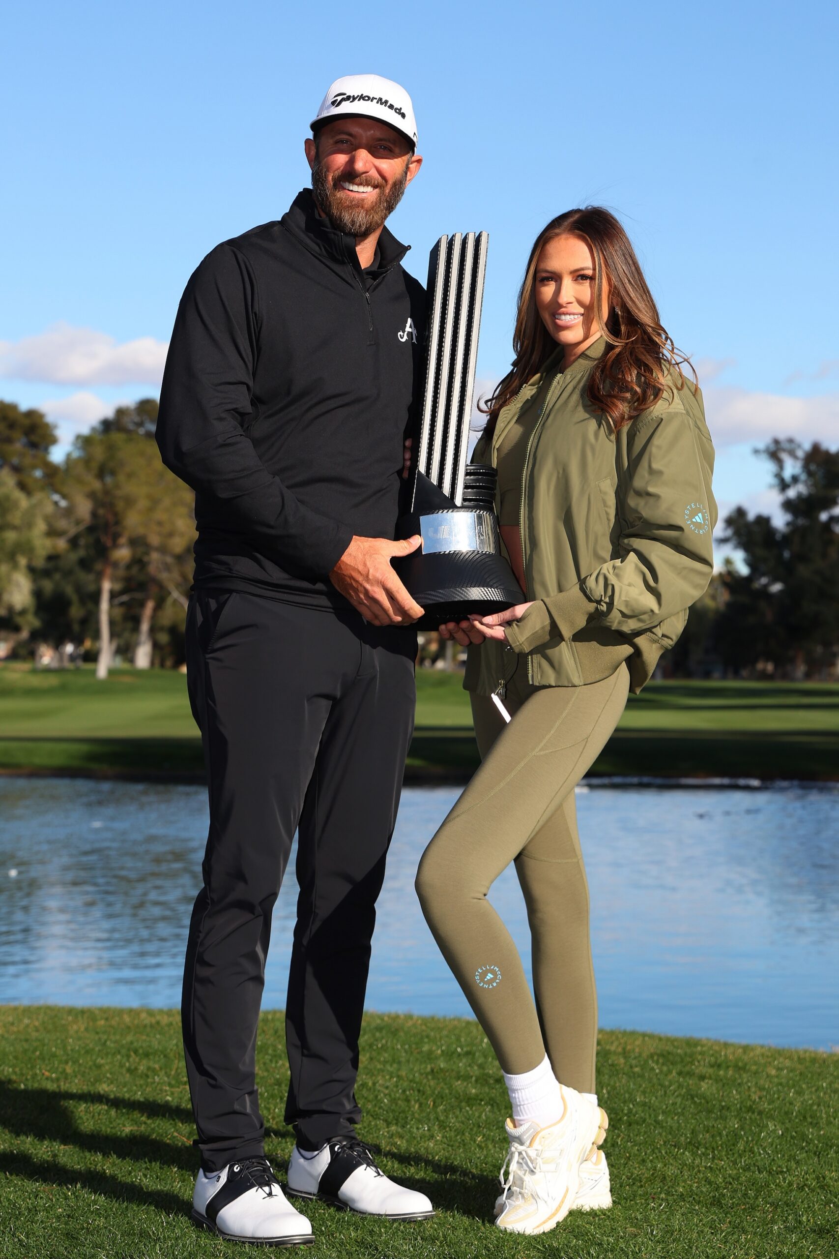 Captain Dustin Johnson of 4Aces GC poses with his wife Paulina Gretzky and the individual trophy after winning during day three of the LIV Golf Invitational - Las Vegas at Las Vegas Country Club on February 10, 2024 in Las Vegas, Nevada.