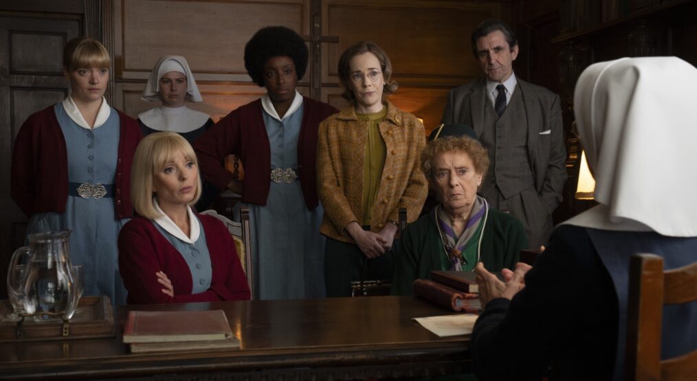 CALL THE MIDWIFE, standing from left: Natalie Quarry, Molly Vevers, Renee Bailey, Laura Main, Stephen McGann, Seated from left: Helen George, Linda Bassett, Jenny Agutter, (Season 15, episode 1506, aired in the US on April. 26, 2026). photo: Olly Courtney / ©PBS/Neal Street Prod. / courtesy Everett Collection
