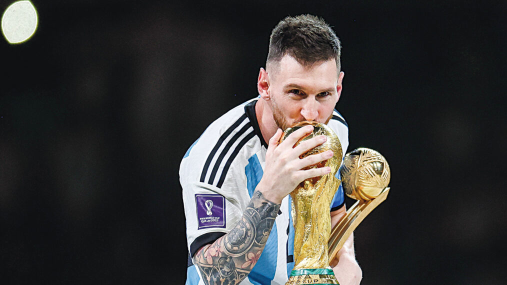LUSAIL CITY, QATAR - DECEMBER 18: Lionel Messi of Argentina kisses the FIFA World Cup Qatar 2022 Winners' Trophy while holding the adidas Golden Boot award after the FIFA World Cup Qatar 2022 Final match between Argentina and France at Lusail Stadium on December 18, 2022 in Lusail City, Qatar.