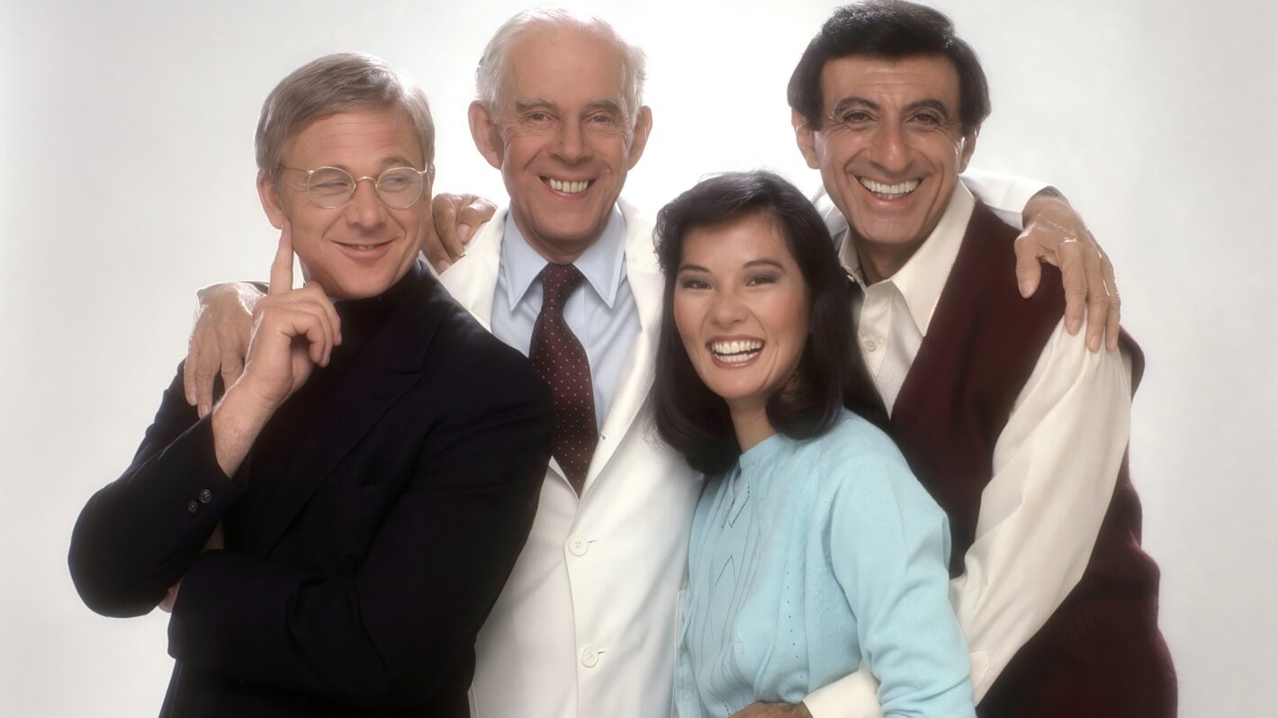 AFTER MASH, from left: William Christopher, Harry Morgan, Jamie Farr, Rosalind Chao, (1983), 1983-1985. ph: Mario Casilli/TV Guide/TM and copyright © 20th Century Fox Television. All rights reserved./Courtesy Everett Collection.