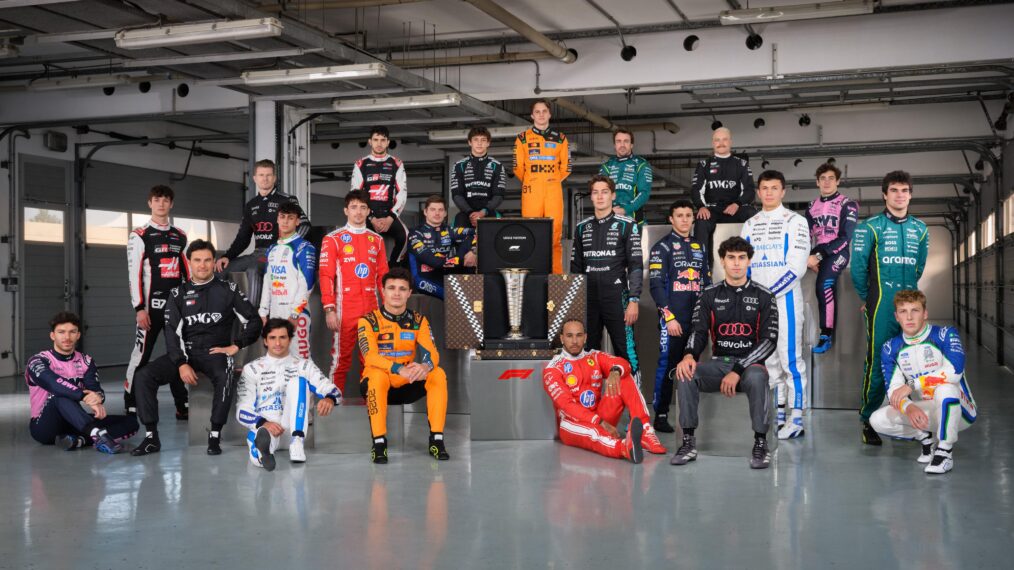 The 2026 Formula 1 Grid poses with the World Drivers Championship trophy.