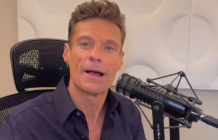 Ryan Seacrest sitting in his chair for his radio show