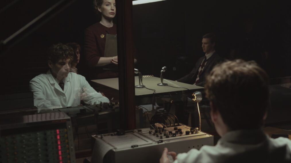 Unabomber. Jacob Tremblay (outside glass, seated at table left) as Ted Kaczynski and Annabella Wallis (standing) as Christiana Morgan in Unabomber. Cr. Philippe Bosse/Netflix ©2026