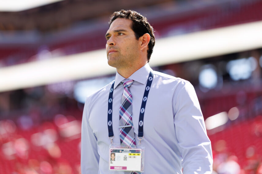 NFL broadcaster Mark Sanchez stands on the field prior to an NFL football game